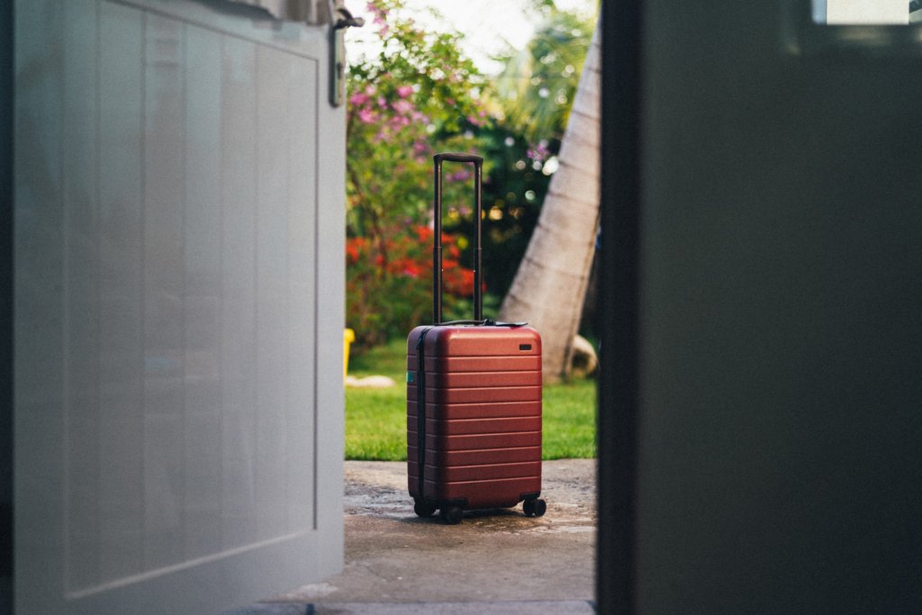 luggage outside of doorway in front of garden