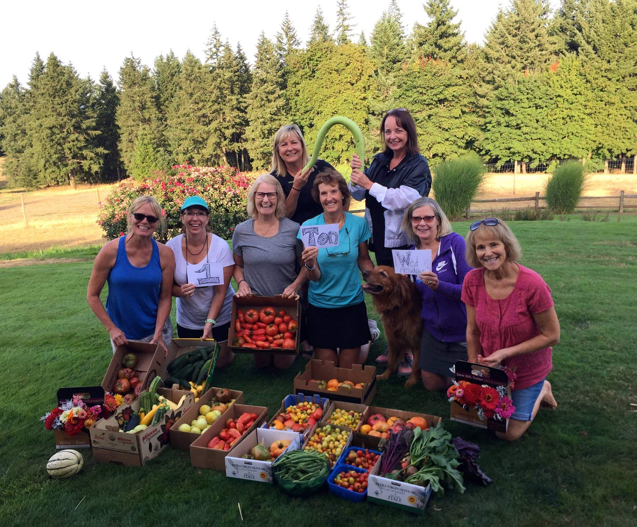 group of women posing with vegetable harvest