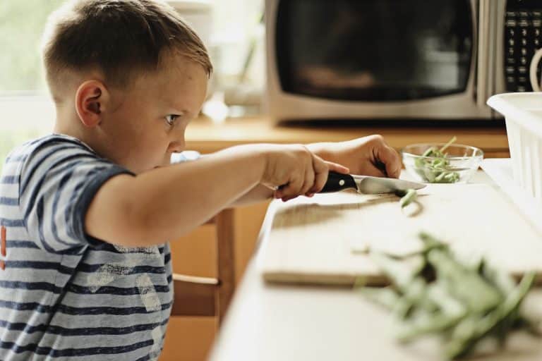child cutting vegetables